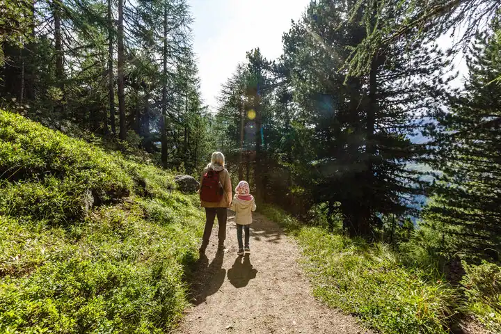 A mother and her child is walking between nature