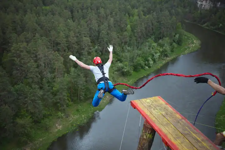 A man bungee jumping in a hilly area