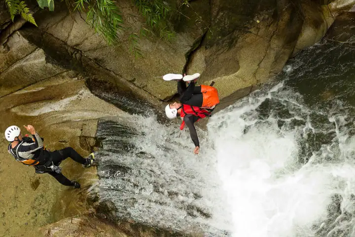 Two man cliff jumping in river