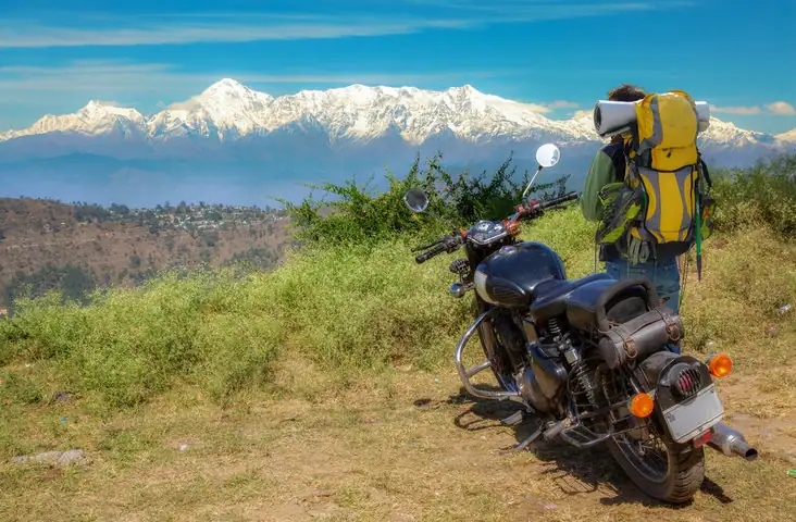 A man with his bike standing an a cliff in Uttarakhand