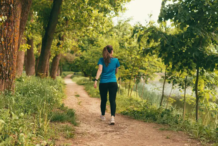 A girl waling in nature like forest.