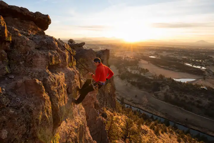 A man rappelling on a cliff