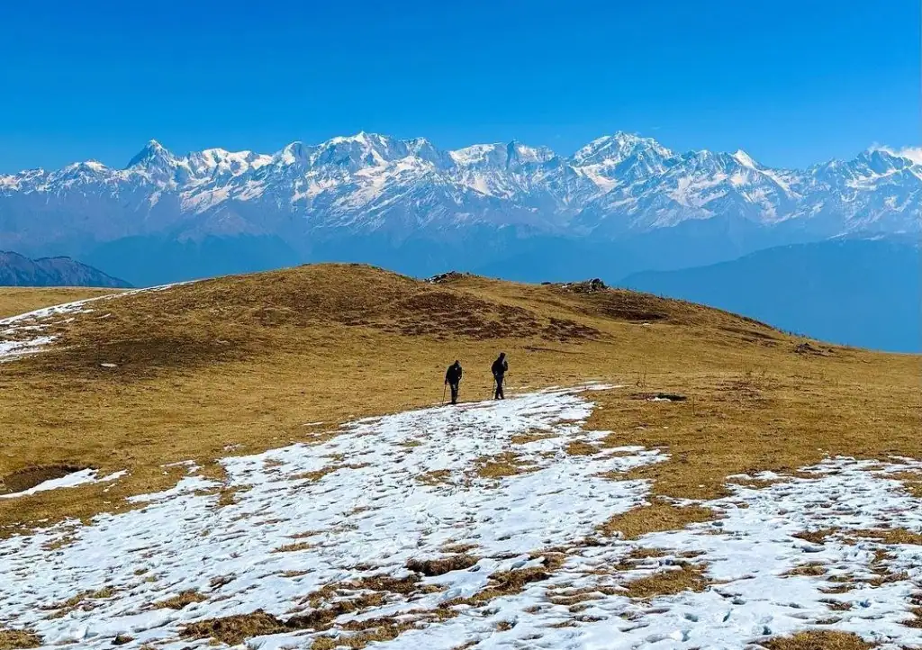 Two people trekking on Dayara Bugyal